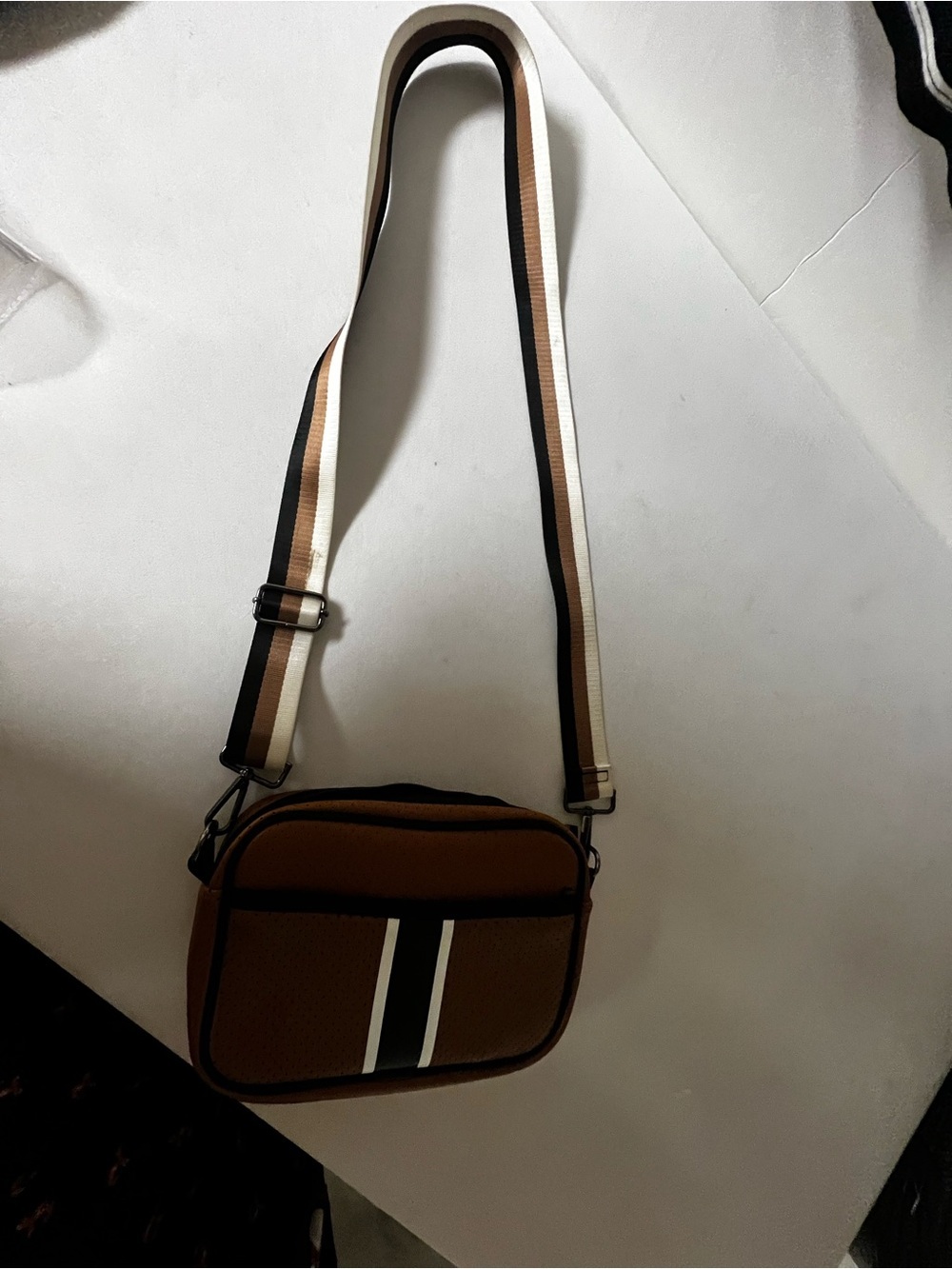 HAUTE SHORE NEOPRENE COMPACT CROSSBODY BAG W/HIDDEN FRONT ZIPPER COMPARTMENT.